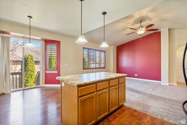 Kitchen featuring light countertops, baseboards, brown cabinets, dark wood-style floors, and vaulted ceiling | Image 7