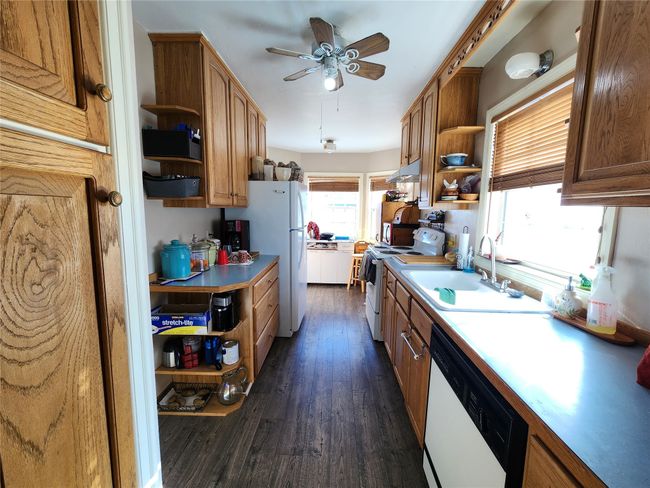 Kitchen featuring a sink, a ceiling fan, open shelves, white appliances, and dark wood-style flooring | Image 20