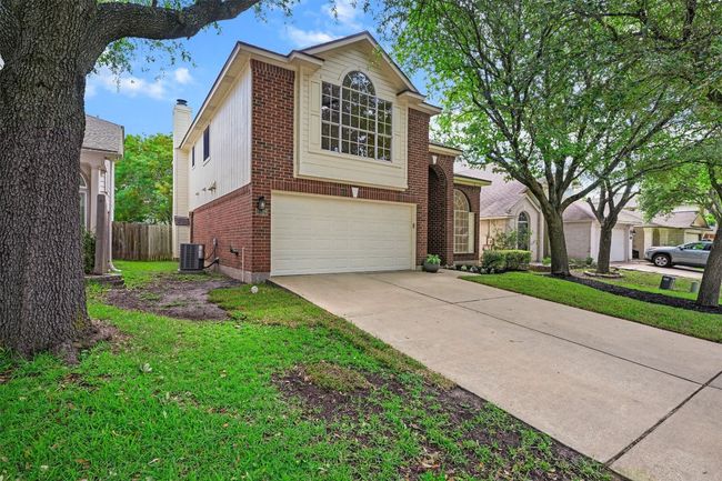 View of front of house with brick siding, an attached garage, and concrete driveway | Image 34
