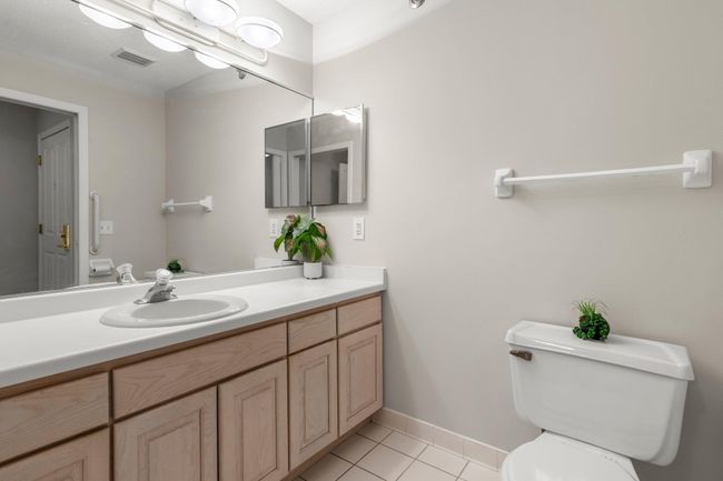 The full bathroom features tile flooring, a spacious single vanity with ample counter space and cabinetry, and a walk-in bathtub/shower combo. | Image 10