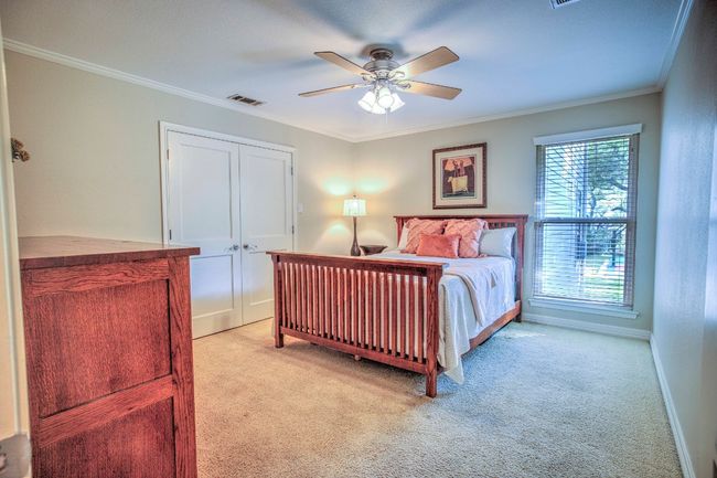 Bedroom featuring large closet, crown molding, baseboards, ceiling fan, and light carpet | Image 33