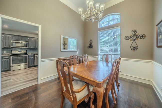 Dining room with a chandelier, ornamental molding, dark wood-style floors, and wainscoting | Image 29