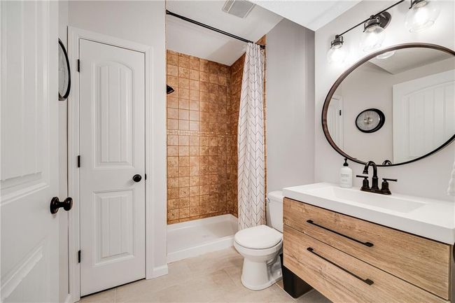 Lower level bathroom with a floor to ceiling tile shower and tile flooring. | Image 45