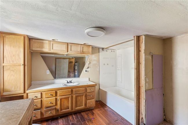 Full bathroom with vanity, wood finished floors, a textured ceiling, and bathing tub / shower combination | Image 20