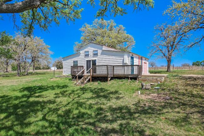 Rear view of house with a deck and a lawn | Image 7