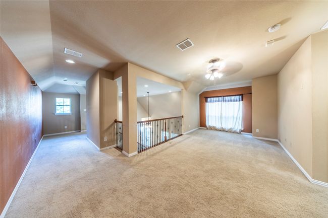 Empty room featuring a ceiling fan, carpet, lofted ceiling, and a smoke detector | Image 23