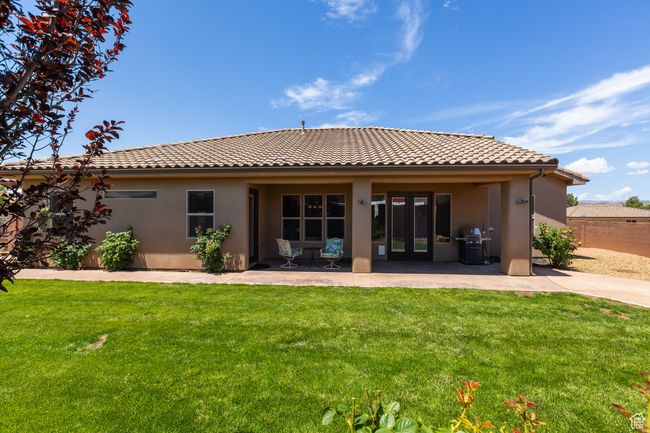 Rear view of property with a tiled roof, stucco siding, and a patio | Image 10