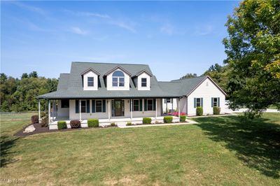 Cape cod home with a front lawn and a porch | Image 1