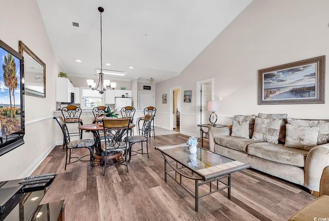 Living room featuring baseboards, an inviting chandelier, and wood finished floors | Image 10