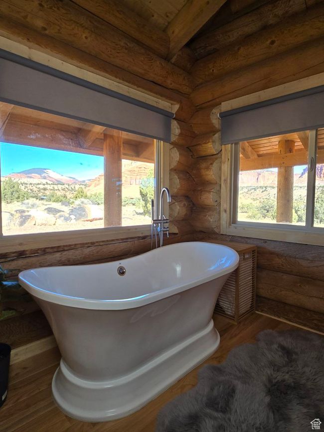 Bathroom with rustic walls, wood finished floors, and a wealth of natural light | Image 80
