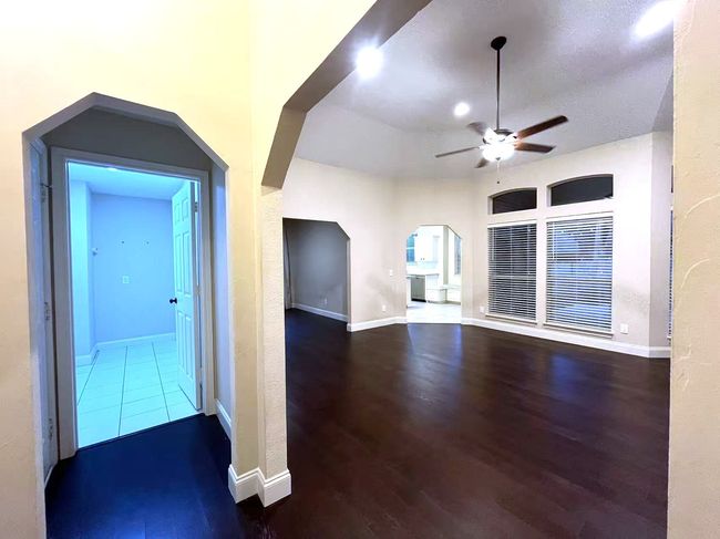 Unfurnished living room featuring arched walkways, ceiling fan, and wood finished floors | Image 21