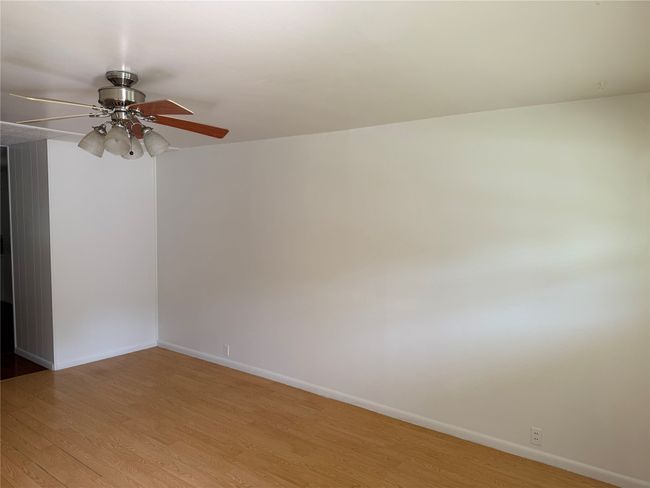 Empty room with wood finished floors and ceiling fan | Image 6
