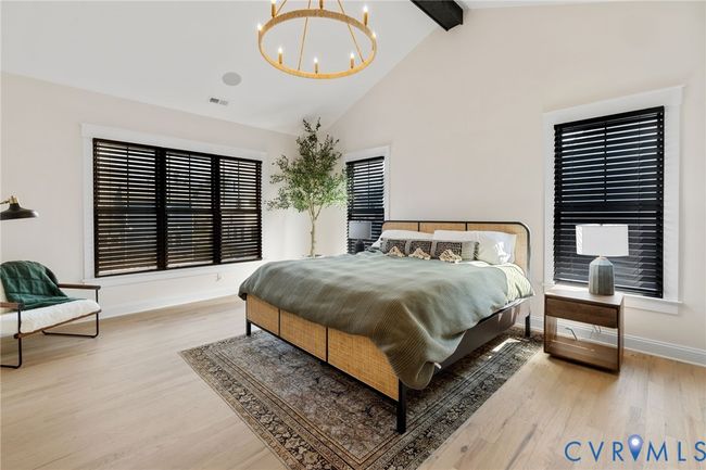 Bedroom featuring beamed ceiling, high vaulted ceiling, wood finished floors, and a chandelier | Image 6