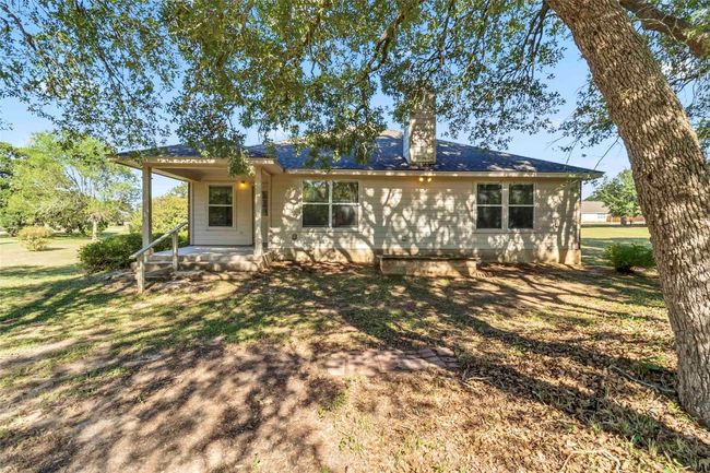 Rear view of property with covered porch, a chimney, and a lawn | Image 34