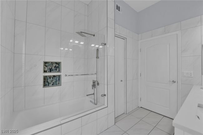 Bathroom with tiled shower / bath combo and tile patterned floors | Image 22