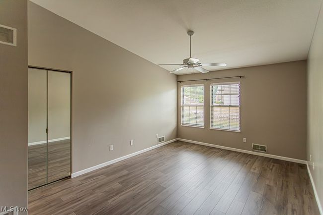 Unfurnished bedroom featuring wood finished floors, a ceiling fan, high vaulted ceiling, and a closet | Image 25
