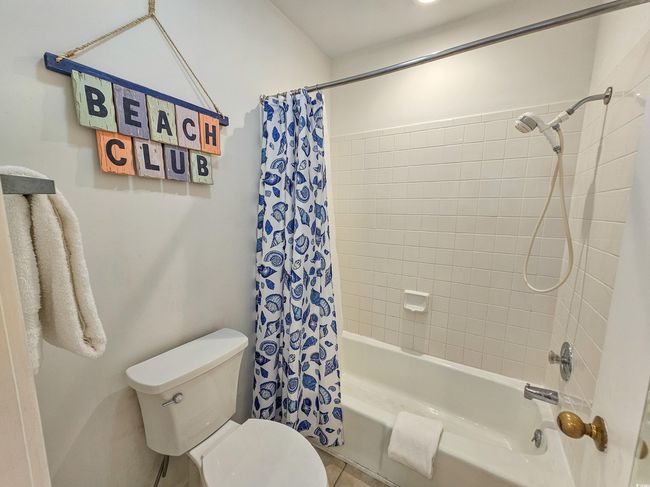 Bathroom with shower / tub combo, toilet, and tile patterned flooring | Image 25
