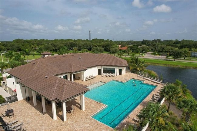 Community pool with a patio area, a water view, and view of scattered trees | Image 28