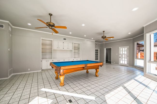 Recreation room featuring crown molding, light tile patterned floors, and visible vents | Image 24