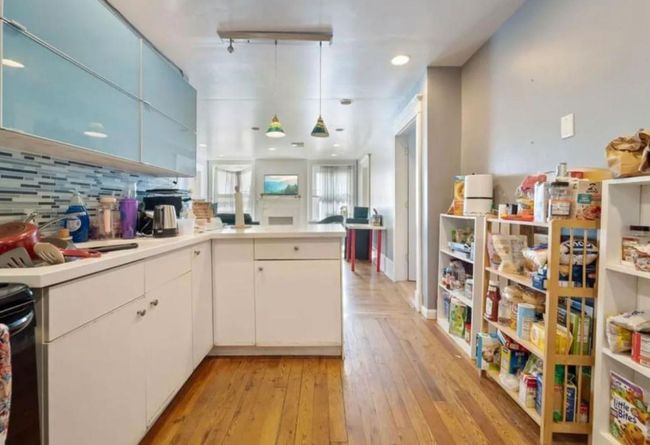 Kitchen featuring tasteful backsplash, light countertops, white cabinets, light wood finished floors, and a peninsula | Image 4
