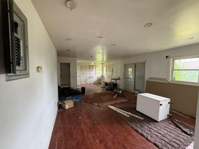 Living area with electric panel and wood finished floors | Image 6