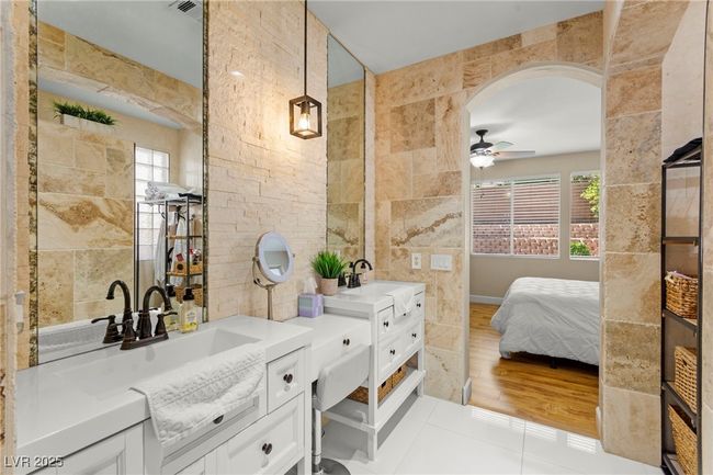 Ensuite bathroom featuring tile walls, two vanities, and a ceiling fan | Image 28