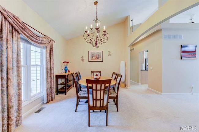 The dining room has formal window treatment and opens up to the living room. | Image 5
