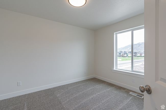 Carpeted spare room with healthy amount of natural light and a mountain view | Image 13