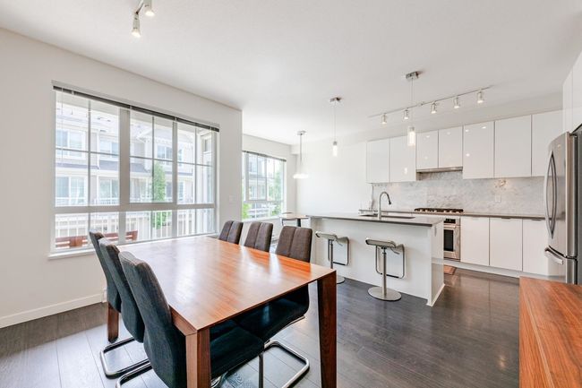 Dining area featuring rail lighting and dark wood-style floors | Image 7