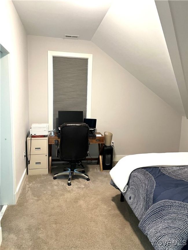 Bedroom 3 with carpet flooring, lofted ceiling, and an office area | Image 17