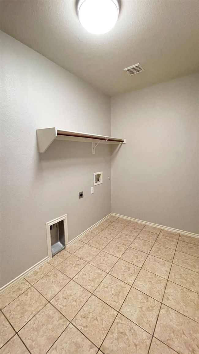 Washroom featuring hookup for a washing machine, hookup for an electric dryer, and light tile patterned flooring | Image 31