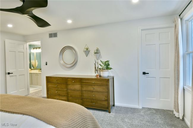 Carpeted bedroom featuring visible vents, baseboards, recessed lighting, and ensuite bath | Image 27
