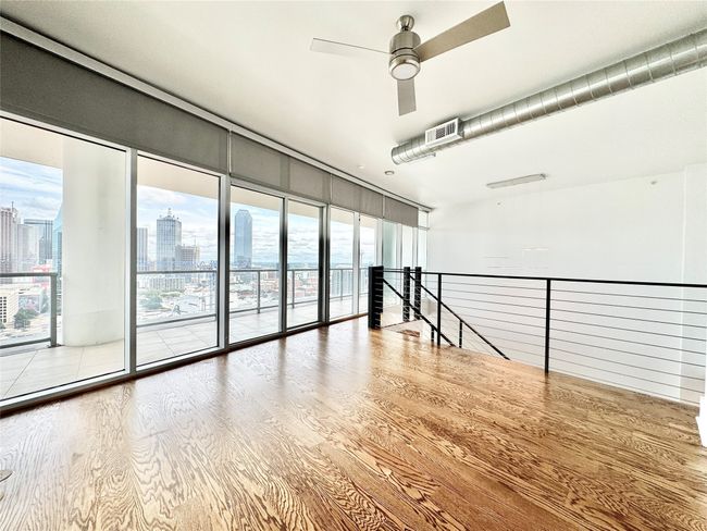 Unfurnished room with a view of skyline, wood finished floors, and a ceiling fan | Image 8