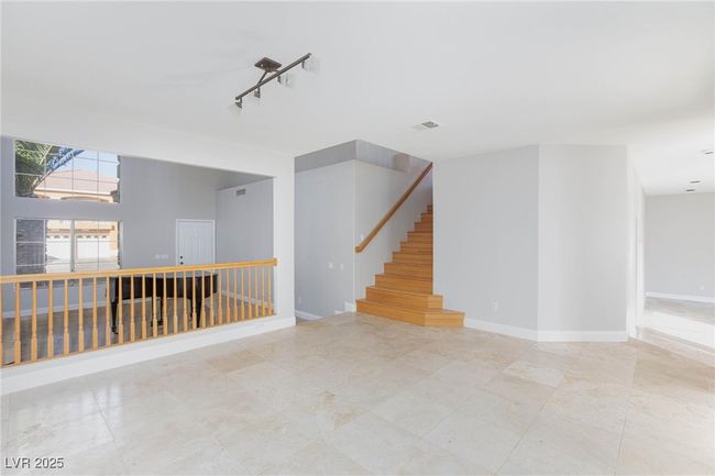 Empty room featuring stairway, visible vents, and baseboards | Image 7