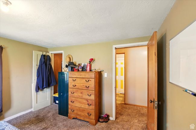 Bedroom featuring a textured ceiling, carpet floors, and baseboards | Image 14