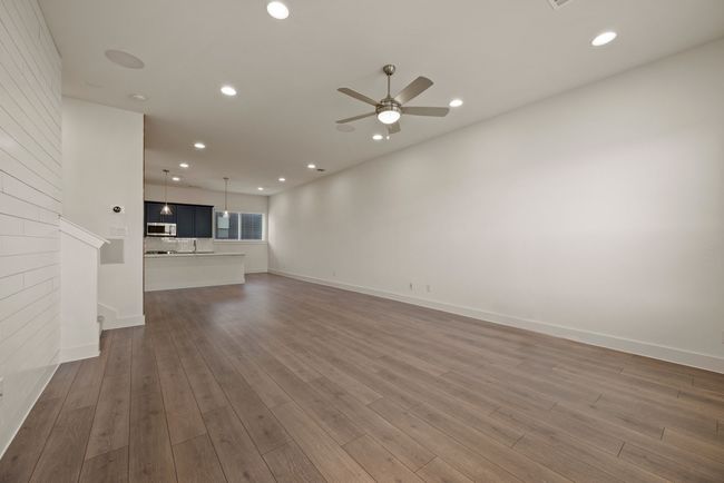 Unfurnished living room with baseboards, wood finished floors, recessed lighting, and ceiling fan | Image 11