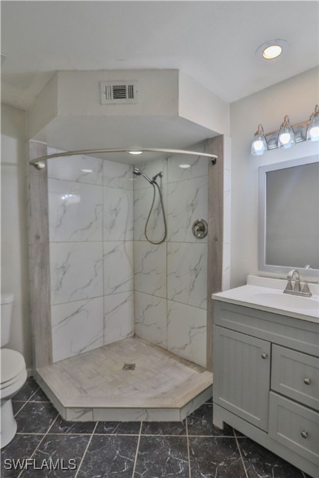 Bathroom with toilet, marble finish flooring, vanity, a marble finish shower, and recessed lighting | Image 8