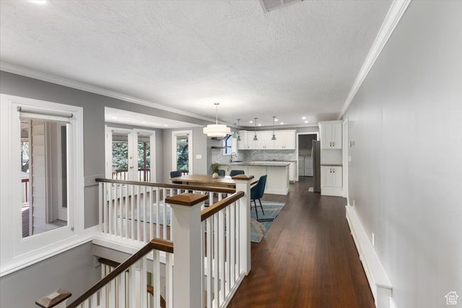 Hallway featuring crown molding, a textured ceiling, recessed lighting, an upstairs landing, and dark wood-style floors | Image 18