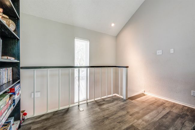 Spare room with wood finished floors, vaulted ceiling, and baseboards | Image 13