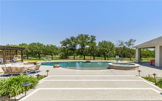 View of pool with a pergola, a patio area, a pool with connected hot tub, an outdoor living space, and fence | Image 24