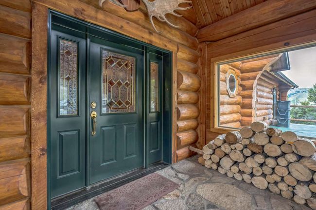 Doorway to property featuring log exterior and a porch | Image 21