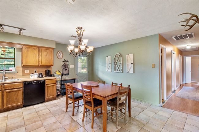 Dining room featuring a textured ceiling, a chandelier, and light tile patterned flooring | Image 5
