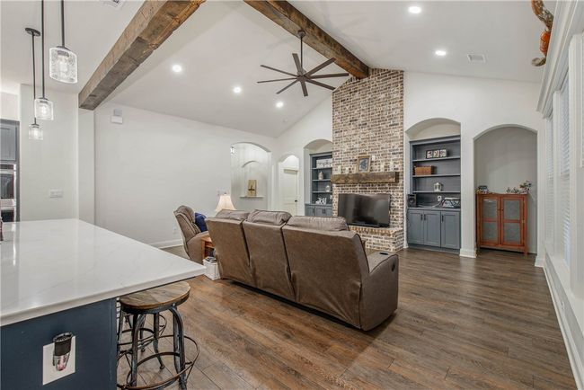 Living area featuring arched walkways, dark wood-style flooring, baseboards, and a ceiling fan | Image 7