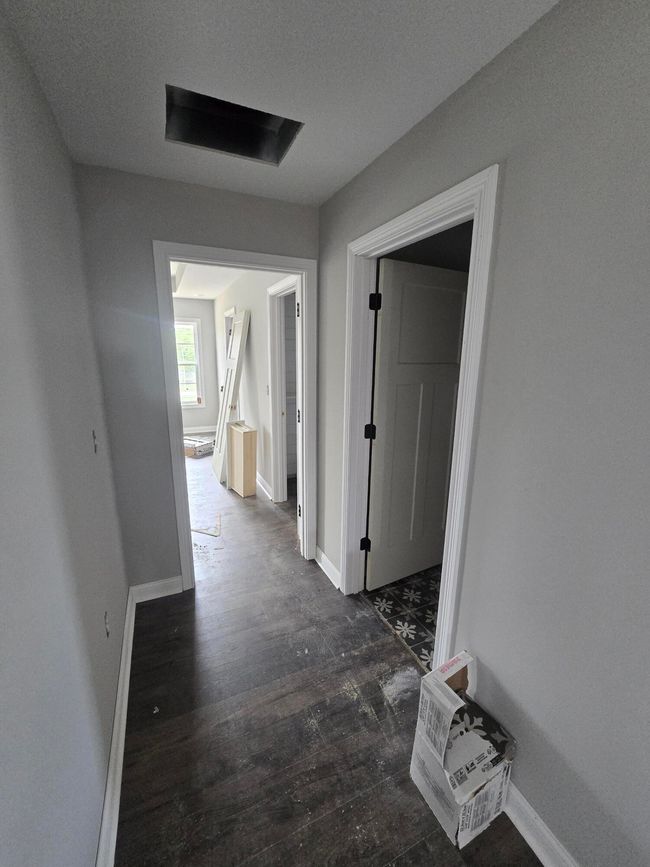 Small hall off livingroom leads to utility room and primary suite | Image 12