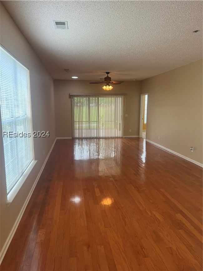 Empty room featuring a textured ceiling, ceiling fan, and dark hardwood / wood-style floors | Image 9