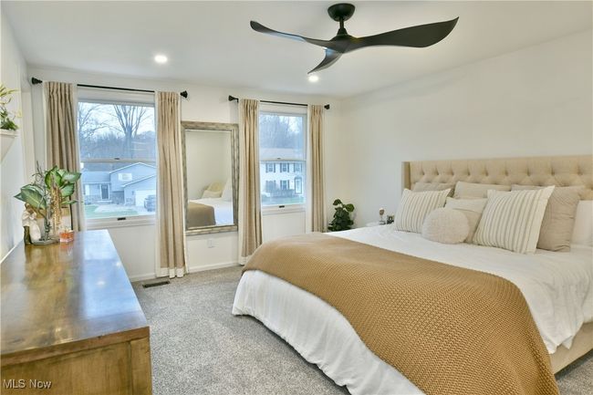 Carpeted bedroom with visible vents, baseboards, multiple windows, and a ceiling fan | Image 24