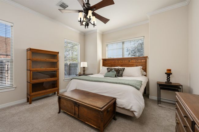 Just up from the sitting room is the primary bedroom full of windows. A large closet is hidden from the camara's view | Image 11