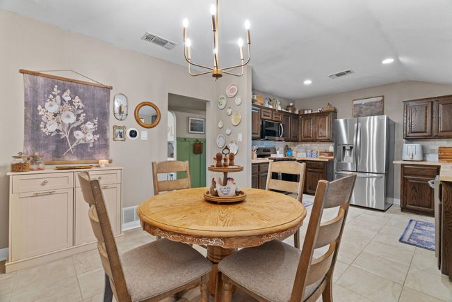 Dining space featuring a chandelier, light tile patterned floors, recessed lighting, and vaulted ceiling | Image 12