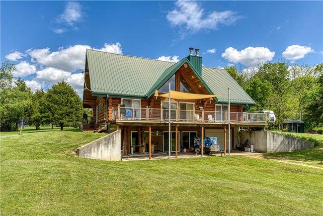 Back of property with a yard, a chimney, log exterior, and a wooden deck | Image 7