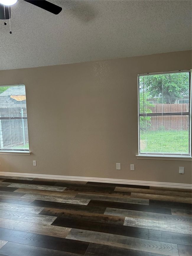 Empty room featuring hardwood / wood-style flooring, ceiling fan, and a textured ceiling | Image 11